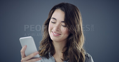 Buy stock photo Message, phone and happy woman in studio for texting, social media blog and online post. Smile, technology or person with mobile for subscription, space and dating app notification on dark background