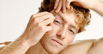 Portrait, man and tweezers in studio for hair removal, beauty maintenance and skincare routine. Male person, tools and pluck to shape eyebrows, facial grooming and transformation on white background