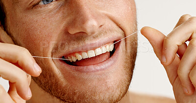 Buy stock photo Oral health, floss and man in studio with hygiene, wellness and mouth routine in morning. Dental care, fresh breath and person with string for cleaning teeth with plaque removal by white background.