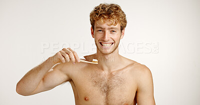 Buy stock photo Dental care, portrait and man brushing teeth in studio for fresh breath, wellness or plaque removal. Morning, health and person with toothbrush for cleaning mouth with hygiene by white background.