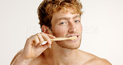 Buy stock photo Oral care, portrait and man brushing teeth in studio for fresh breath, wellness or plaque removal. Morning, dental hygiene and male person with toothbrush for cleaning mouth by white background.