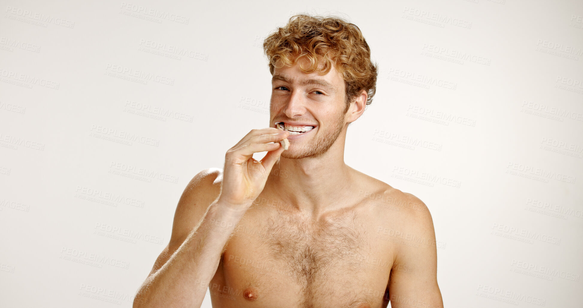 Buy stock photo Dental care, happy and man brushing teeth in studio for fresh breath, wellness or plaque removal. Portrait, oral health and person with toothbrush for cleaning mouth with space by white background.