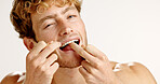 Dental health, floss and portrait of man in studio with hygiene, wellness and mouth routine. Oral care, fresh breath and person with string for cleaning teeth with plaque removal by white background.