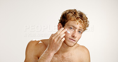 Buy stock photo Beauty, moisturizer and portrait of man in studio to apply cream to face for antiaging treatment. Hydration, lotion and skincare with model isolated on white background for facial product application