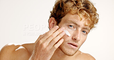 Buy stock photo Beauty, lotion and portrait of man in studio to apply cream to face for antiaging treatment. Hydration, moisturizer and skincare with model isolated on white background for facial product application