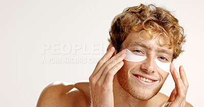 Buy stock photo Portrait, eye patches and man in studio, skincare and dermatology on white background. Face, happy person and model with beauty, spa wellness and facial with detox, treatment and cosmetics with mask