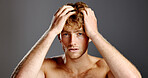 Portrait, confident man and hair care in studio for beauty, grooming and texture on gray background. Face, hairstyle and person at salon for scalp treatment, barber or growth cosmetics for aesthetic