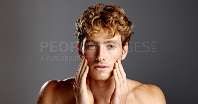 Buy stock photo Man, beauty and facial hair in portrait for skincare, grooming and dermatology on a grey background. Redhead, self care and male model serious with cosmetics, confidence or beard with hand on face