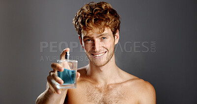 Buy stock photo Perfume, portrait and smile of man in studio with spray bottle for aroma, fragrance or fresh smell. Cologne, product and satisfaction with happy person on gray background for essence scent in glass