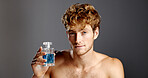 Cologne, cosmetics and portrait of man in studio with spray bottle for aroma, fragrance or fresh smell. Confident, perfume and product with person on gray background for essence scent in glass