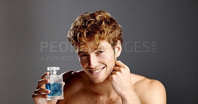 Buy stock photo Cologne, face and product with man in studio with spray bottle for aroma, fragrance or fresh smell. Perfume, satisfaction ad smile of happy person on gray background for essence scent in glass