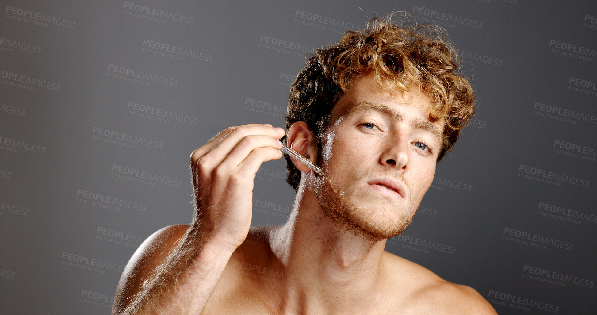 Buy stock photo Face, serum and man with skincare, cosmetics and dermatology on gray studio background. Portrait, happy person and model with treatment, beauty and beard oil product in pipette for hydration and glow