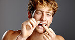 Dental health, flossing and portrait of man in studio with fresh breath, grooming or plaque removal. Oral care, wellness and person with string for clean teeth with mouth routine by gray background.