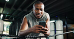 Fitness, black man or phone in boxing ring for contact, training schedule or latest sports news on break. Boxer, rest or mobile at gym for social media, status update or online post on exercise forum