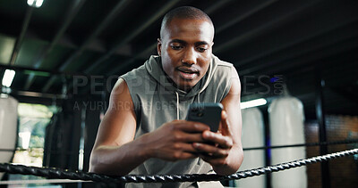 Buy stock photo Fitness, black man or phone in boxing ring for contact, training schedule or latest sports news on break. Boxer, rest or mobile at gym for social media, status update or online post on exercise forum