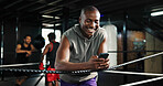 Smile, athlete and man with phone in boxing ring for texting, social media and fight schedule. Male person, laugh and cellphone for chatting, streaming battle and email for progress results at gym