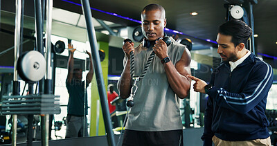 Buy stock photo Coach, teaching and man with rope machine for advice, exercise and support in bodybuilding. Personal trainer, biceps and athlete in training with gym equipment, muscle and workout for fitness tips