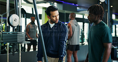 Buy stock photo Man, fitness and instructor with client in gym for instructions, tips or demonstration on machine. Male person, personal trainer or coach with member for workout, exercise or guidance in health club
