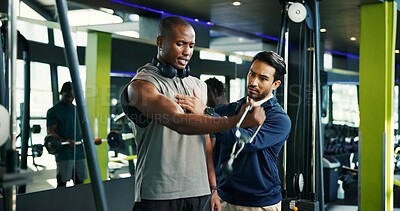 Buy stock photo Coach, teaching and man with cable machine, exercise and support in bodybuilding. Personal trainer, advice or athlete in training with gym equipment for muscle, power and workout for fitness tips