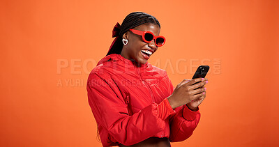 Buy stock photo Phone, fashion or excited black woman in studio for discount message, sale or bargain deal. Space, notification or happy model on orange background for trendy sunglasses, good news or cool clothes
