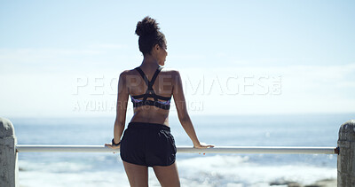 Buy stock photo Woman, exercise and thinking on break at beach promenade, space and sky for fitness. African runner, girl and reflection with back for workout, training and rest by sea with perspective in Nigeria