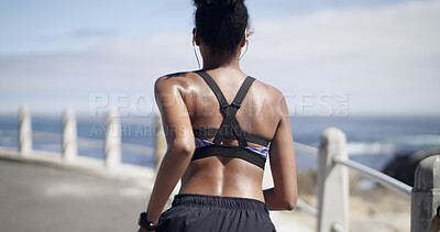 Buy stock photo Back view, woman or running with fitness on promenade for workout, exercise or training. Active, female person or runner with earphones for cardio challenge, health or outdoor wellness by beach
