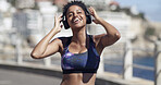 Smile, woman and headphones for fitness in city for audio, listening to music and exercise podcast. African person, streaming and good mood, workout playlist and sports training of marathon practice