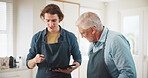 Men, chef and apron with tablet in home cooking for hospitality or culinary skill in kitchen. Mature, mentor or person with help, technology or tutorial for meal prep, house recipe or food cuisine