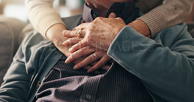 Buy stock photo Comfort, hands and elderly couple in home, bonding and affection for relationship in lounge and hug. Retirement, care and love in living room, senior people and embrace for support in house or trust