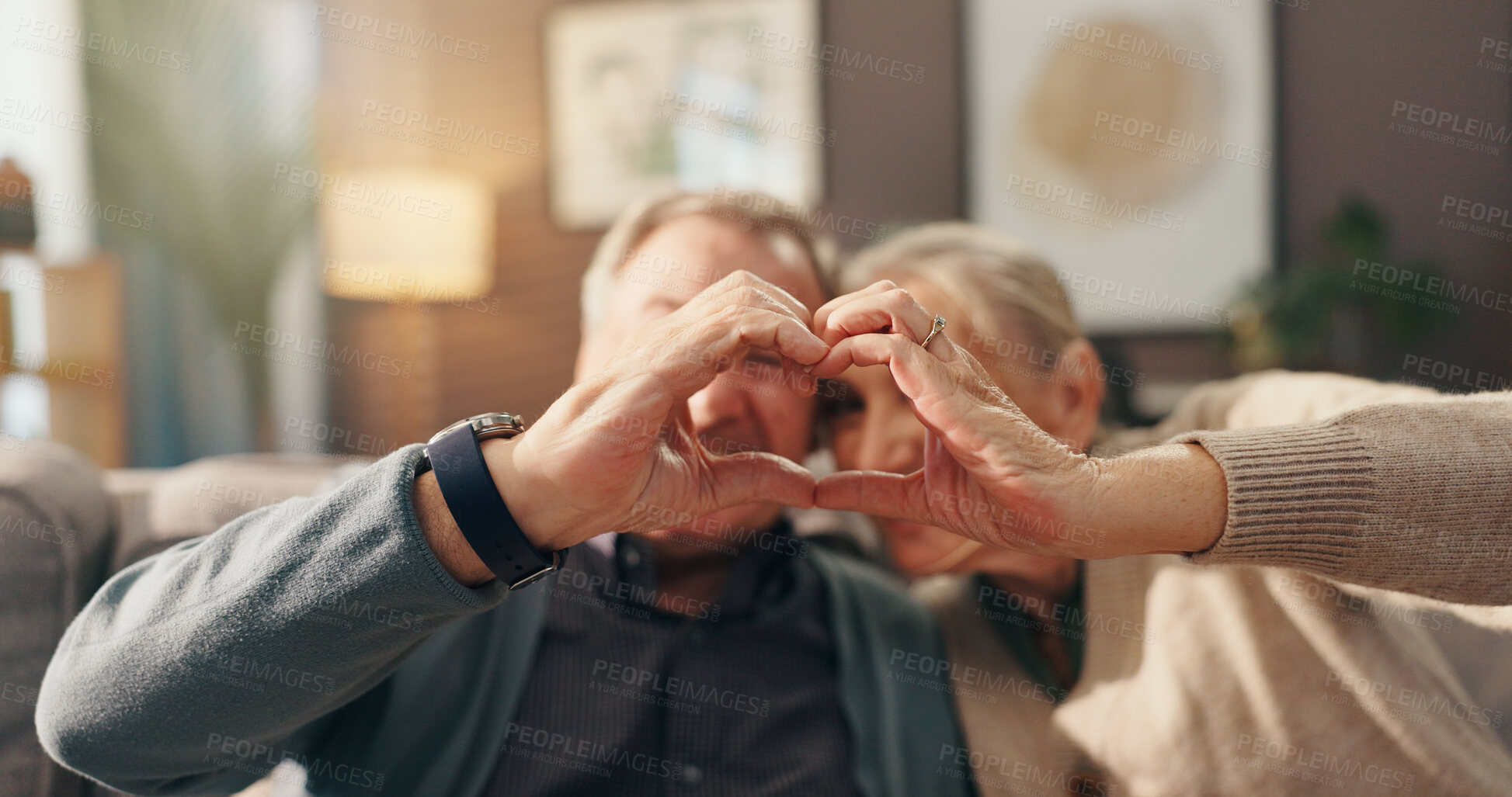 Buy stock photo Senior couple, love and heart hands on sofa for romance, commitment or marriage at retirement home. Elderly, man and woman with emoji, shape or romantic gesture for old relationship together at house