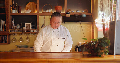 Buy stock photo Asian man, chef and counter at restaurant for food preparation, cooking and hospitality service. Mature person, professional and culinary skills for traditional cuisine, catering and business owner