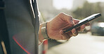 Business, hands and man with phone in city for ride booking, check schedule or morning commute. Professional, person or smartphone outdoor for reading notifications, text message or internet browsing
