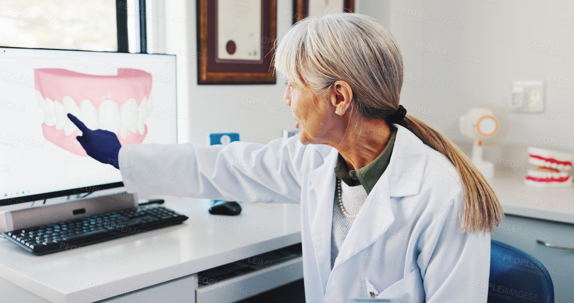 Buy stock photo Medical, explain and dentist with teeth on screen for help, surgery information or diagnosis. Dentistry, orthodontist and mature woman in practice for dental implant and tooth alignment procedure