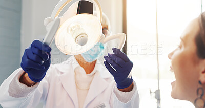 Buy stock photo Woman, dentist and light for checkup at clinic for dental care, tooth cleaning and medical procedure. Professional, patient and lamp for mouth inspection, oral hygiene and wellness of decay treatment