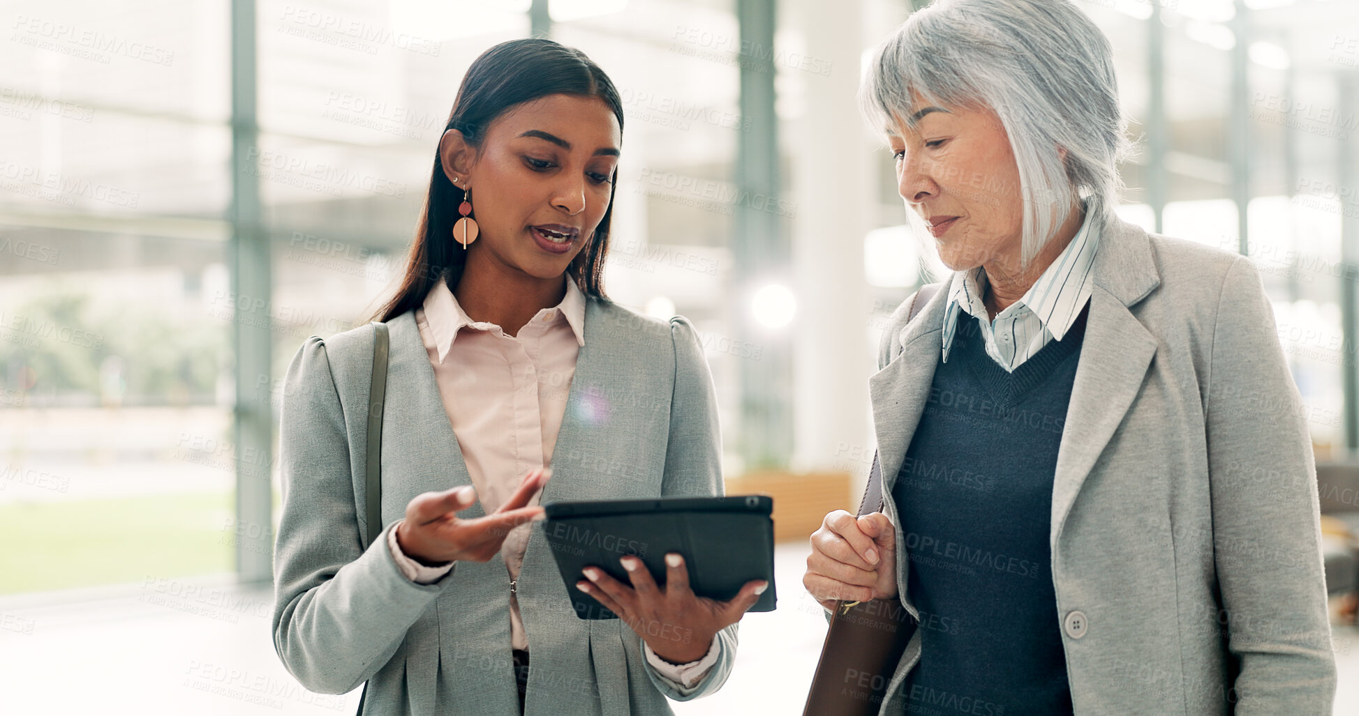 Buy stock photo Business, tablet and women in lobby, conversation and online investment with coaching. Employees, people and financial advisors in hallway, tech or digital app for inflation report, mentor or advice