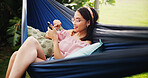 Hammock, relax and woman with smartphone, smile and social media with connection, break and chatting. Outdoor, mobile user and person with cellphone, texting and message to contact and online reading