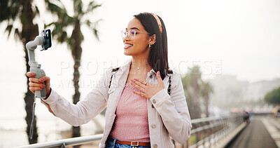 Buy stock photo Phone gimbal, content creation and woman in city for travel, broadcast or tourism guide. Mobile, smile and influencer outdoor for social media, live stream or thank you to fans on holiday with space