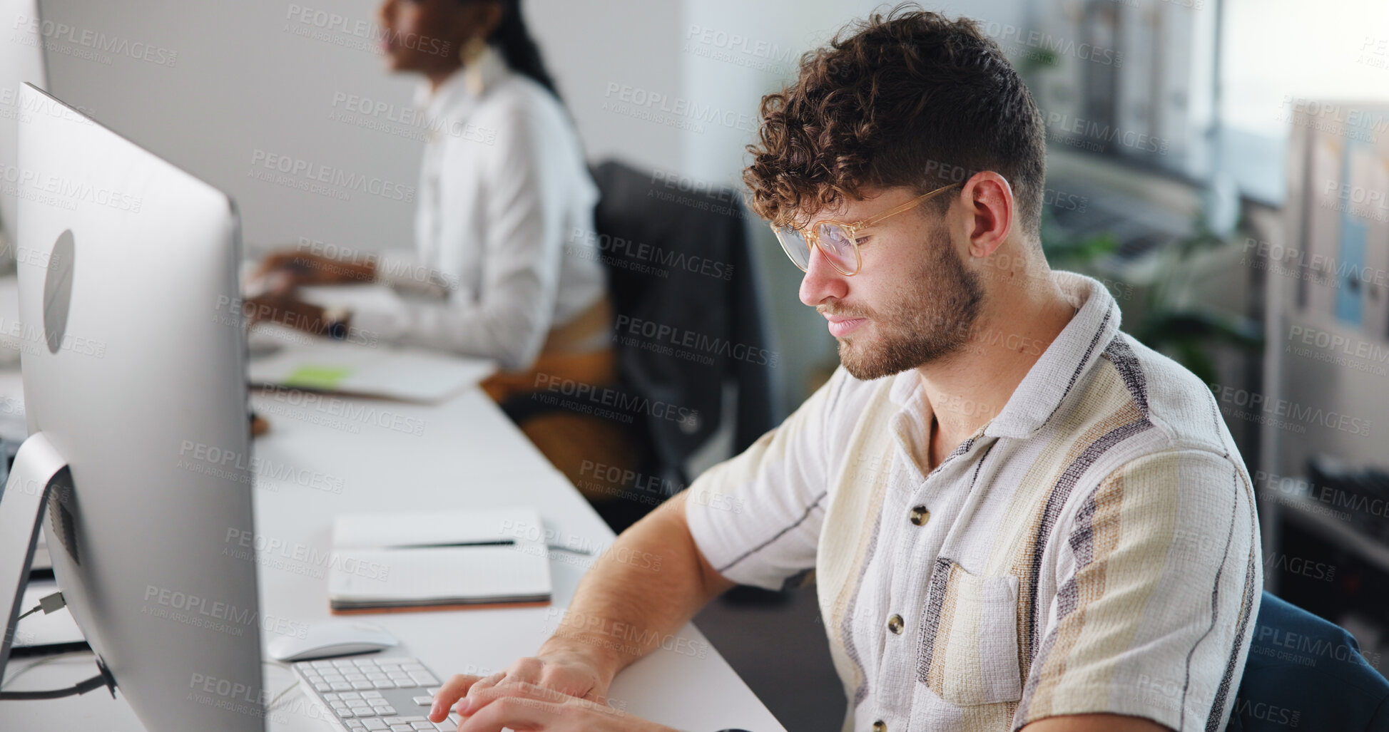 Buy stock photo Computer, creative and typing with business man at work for design, development or review. Artistic, planning and technology with graphic designer at desk in coworking office for website launch
