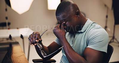 Buy stock photo Photography, editor and eye strain with black man in studio for photoshoot, deadline and retouching. Tired, production process and fatigue with person on set for overworked, airbrush and media export