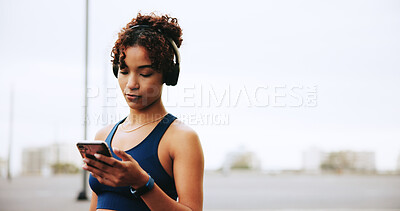 Buy stock photo Mobile, fitness and woman in city with headphones for exercise, streaming podcast or radio online. Phone, athlete and listening to music outdoor for motivation playlist, workout audio or sky space