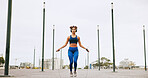 Fitness, skipping and woman in city for exercise, activity or challenge for weightloss outdoor. Sports, energy and female athlete with jump rope for cardio workout or training for health in town.