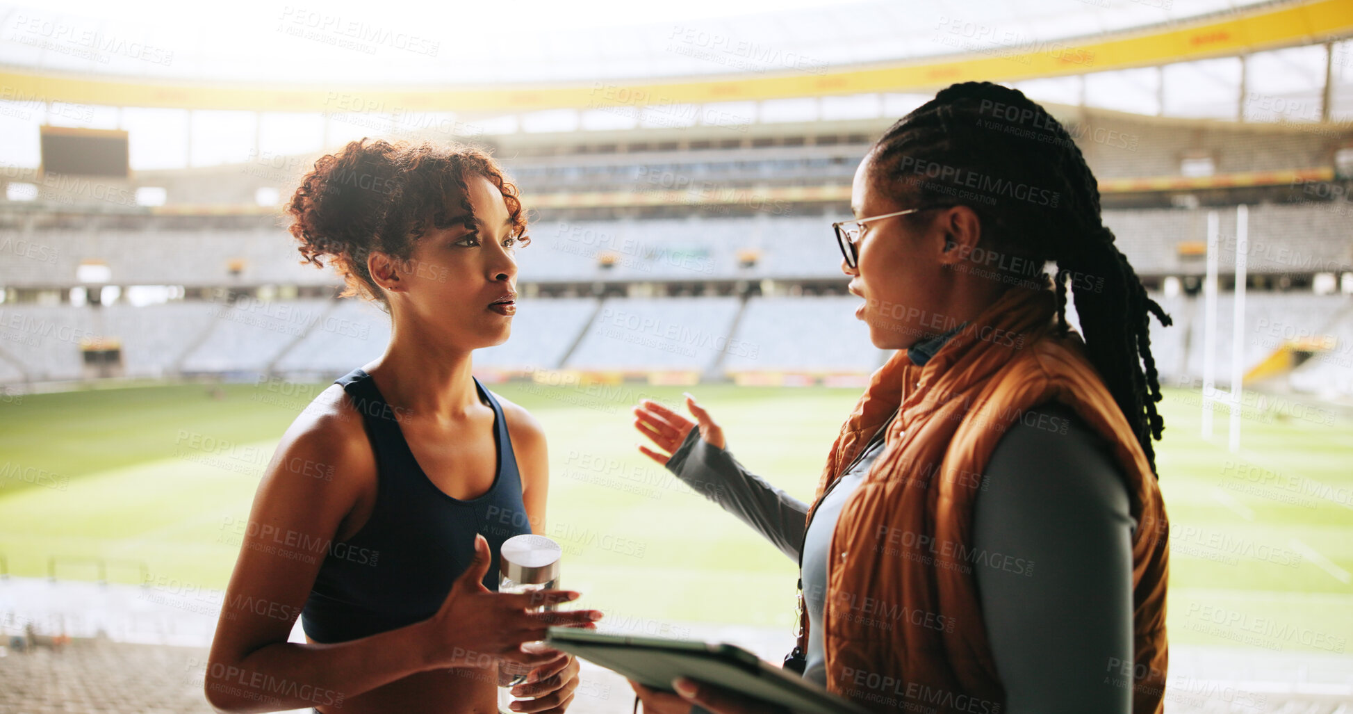 Buy stock photo Women, sports coach and player with conversation, advice or feedback with training. People, personal trainer or professional athlete with discussion, planning or outdoor stadium with schedule or help