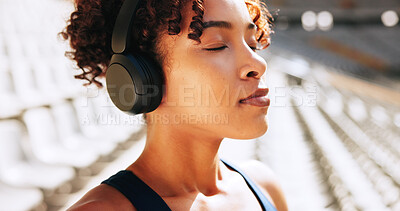 Buy stock photo Breathing, fitness and music with woman outdoor in stadium for break, recovery or rest from training. Exercise, headphones and streaming with tired athlete at venue for competition, sports or workout