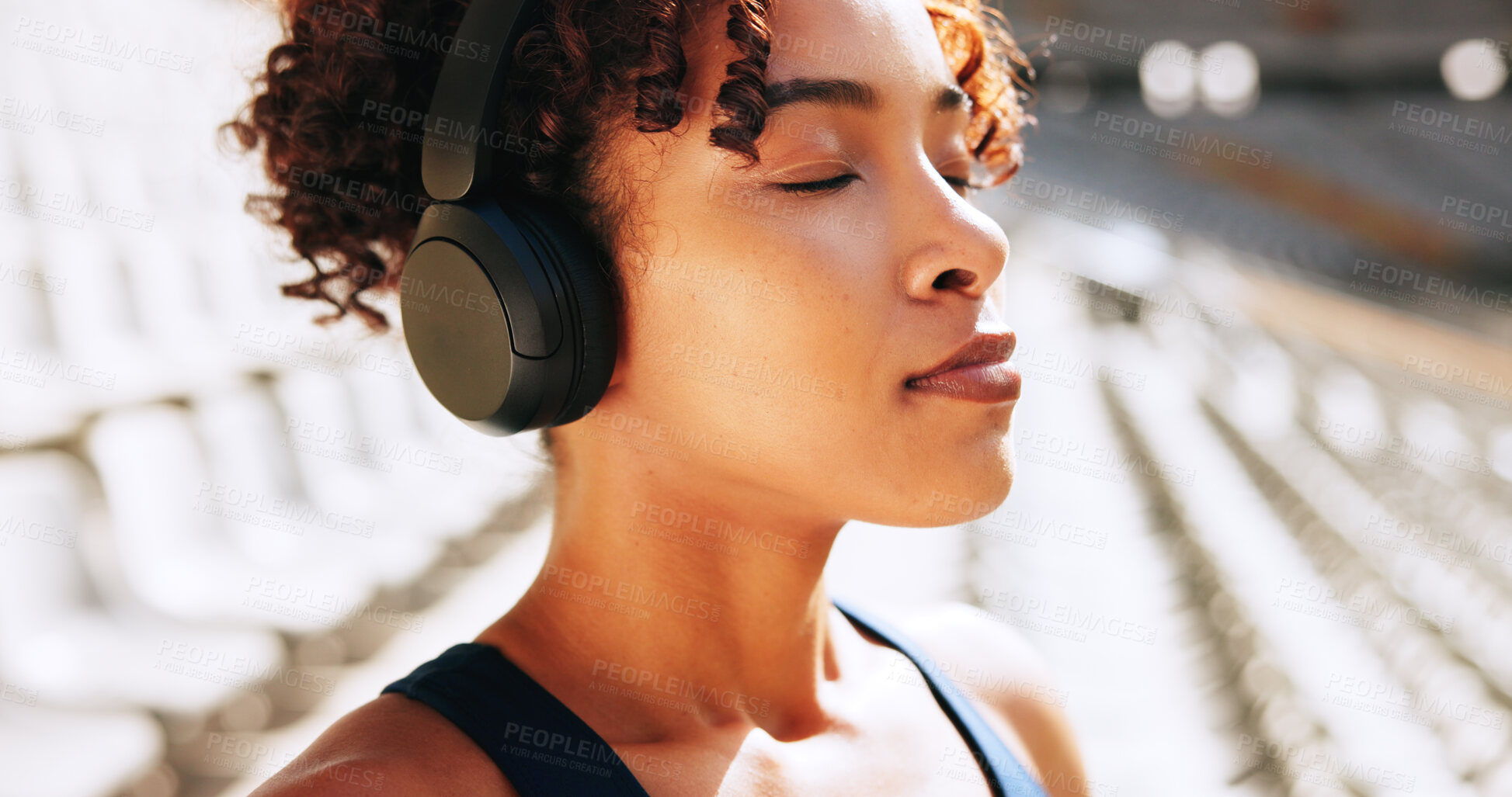 Buy stock photo Breathing, fitness and music with woman outdoor in stadium for break, recovery or rest from training. Exercise, headphones and streaming with tired athlete at venue for competition, sports or workout