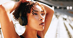 Breathing, fatigue and music with woman in sports stadium for break, recovery or rest from training. Exercise, headphones and tired with exhausted athlete at outdoor venue for competition or workout