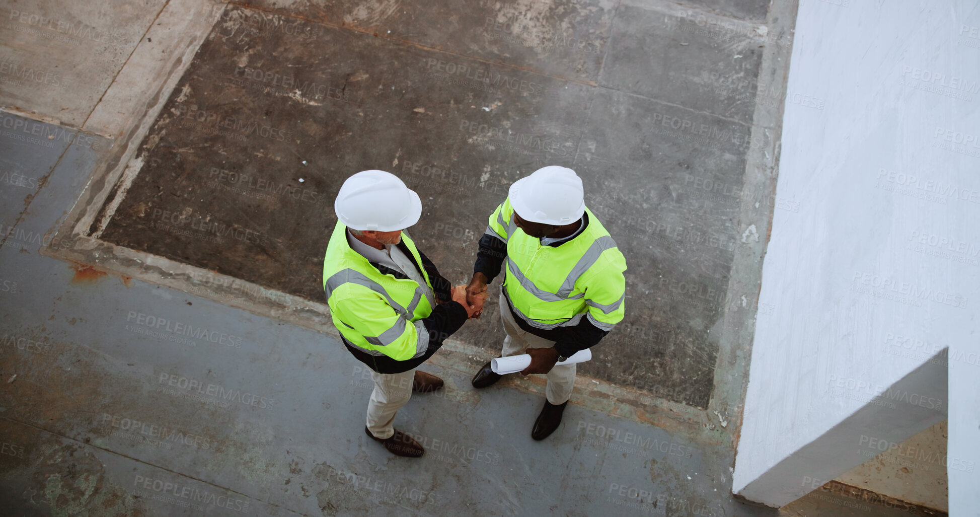 Buy stock photo Above, construction and men with handshake on site for building collaboration, new project or deal. Engineering, contractors and shaking hands with agreement for quality control and safety inspection