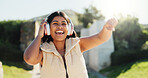 Fashion, headphones and happy woman dance outdoor with energy, freedom and celebration. Listening to music, excited and dancer at park for hip hop, streaming audio and sound for stylish streetwear