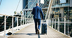 Back view, businessman and travel with suitcase in city for corporate trip or journey on bridge. Man, traveler or walking with luggage for urban business, new career or job opportunity downtown