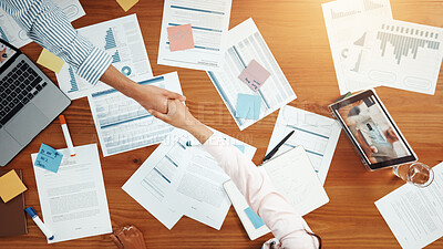 Buy stock photo Above, business people and handshake in meeting with graphs, data analysis and feedback. Shaking hands, collaboration and documents for project, research and tech for chart review with paperwork