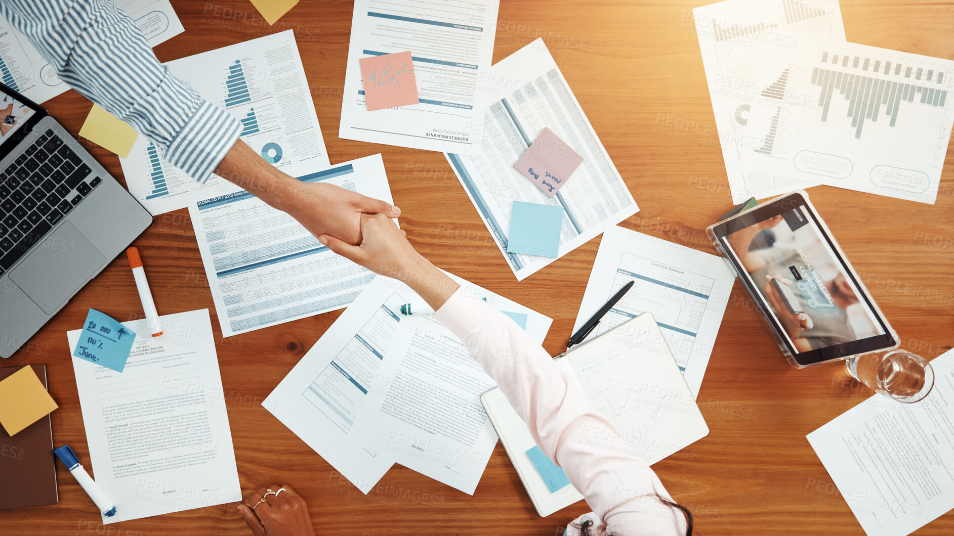 Buy stock photo Above, business people and handshake in meeting with graphs, data analysis and feedback. Shaking hands, collaboration and documents for project, research and tech for chart review with paperwork
